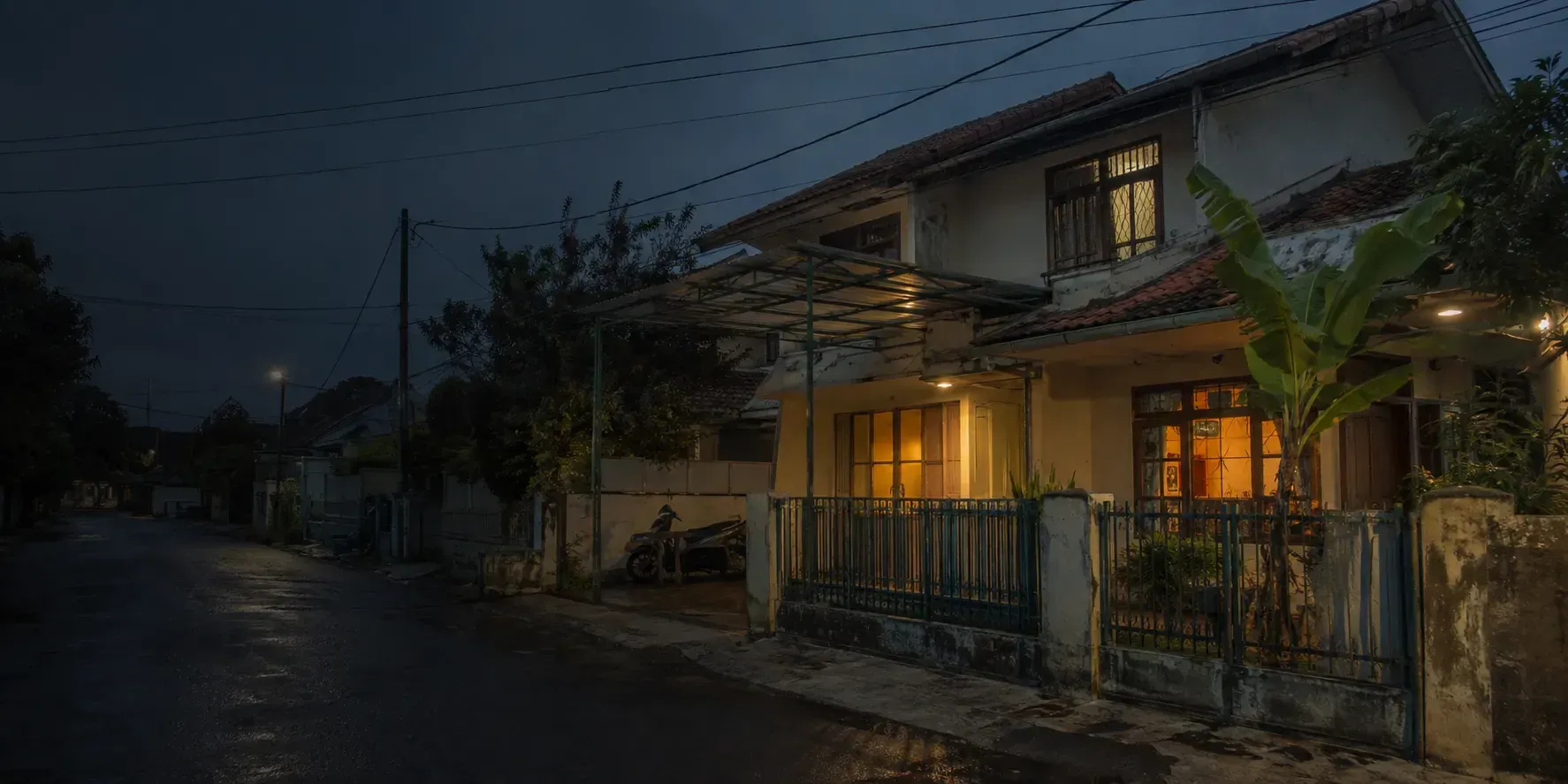 Rumah pada sore hari dengan lampu menyala